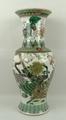 A Kangxi style / 20th century porcelain vase of baluster form famille vert decorated with peacocks, ... 