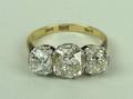 An 18ct gold, platinum and three stone diamond ring, the central old cut diamond, 2ct, flanked by tw... 