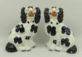 A pair of Staffordshire figures of spaniels, late 19th century, strongly moulded with black and guil... 