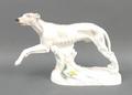 A Meissen porcelain figure of a greyhound modelled to the left with his head slightly turned, his wh... 