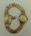 A lady's 9ct gold wristwatch by J.W. Benson, circular dial, on a 9t gold strap, 14.9g total weight.