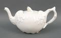 A Swan Potteries white glazed teapot modelled with seaweed and rocaille, with periwinkle shell finia... 