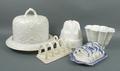 A stoneware stilton cheese dish and cover, mid 19th century, white glazed moulded with panels of lil... 
