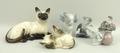 A group of ceramic cat figures, comprising two Lladro, two Beswick Siamese cats, and a Nao cat. (5)