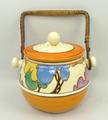 A Clarice Cliff Bizarre pottery biscuit barrel and cover, shape 335, decorated in the 'Blue Autumn' ... 