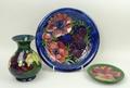 A Moorcroft pottery dish decorated in the 'Anenome' pattern against a blue ground, bears paper label... 
