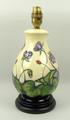 A Moorcroft pottery lamp base, tubelined and hand-painted with lotus flowers against a cream ground,... 