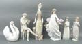 A group of Lladro and Nao porcelain figures, comprising; a swan, seated boy playing a flute, girl wi... 