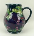 A Moorcroft pottery jug decorated in the 'Finches' pattern against a green ground, impressed and pai... 