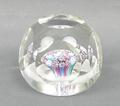 A faceted glass paperweight containing concentric millefiori canes within an opaque latticino ring, ... 