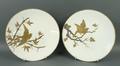 A pair of Brownfield porcelain plates, late 19th century, painted in gold and silver with birds on b... 