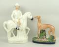 A Staffordshire figure of a greyhound, mid 19th century, modelled standing aside a hare on an oval b... 