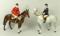 A Beswick Huntsman on brown horse and a Huntswoman on a dappled grey horse, 22cm high.