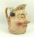 A Sarreguemines majolica character jug, over printed for Mitchell & Co of Belfast Ltd, Old Irish Whi... 