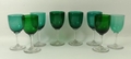 A harlequin set of eight Victorian green and turquoise wine glasses, raised on clear glass stems and... 