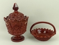 A 19th century pressed glass cup and cover in terracotta red, decorated in the Gothic manner, with t... 
