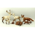 A group of Beswick figures comprising four foxes comprising one recumbent, one seated, and two strid... 