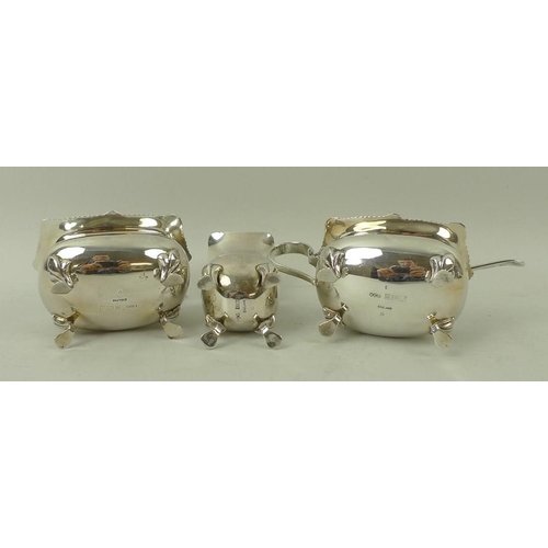 371 - A silver three piece cruet set, comprising salt and mustard with blue glass liners and spoons, and p... 