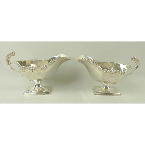 389 - A pair of Edwardian silver sauce boats, the handles with cast jaguar heads, with cast scroll rim, ra... 