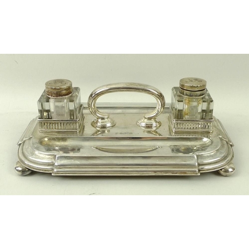 395 - A Victorian silver desk stand, with handle two pen wells, and two square cut glass inkwells with sil... 