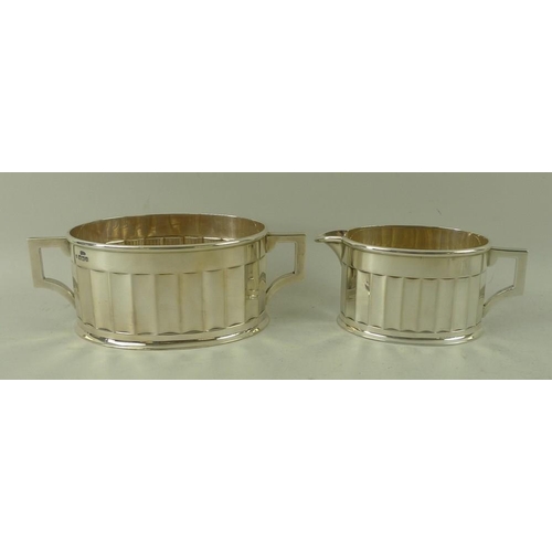 405 - An Art Deco four piece silver tea set, with fluted sides and angular handles, the pots with ebony ha... 