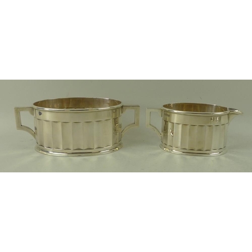 405 - An Art Deco four piece silver tea set, with fluted sides and angular handles, the pots with ebony ha... 