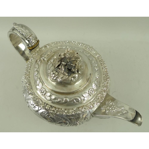 406 - A Georgian silver teapot, the squat embossed floral body with applied cast rim and foliate border, w... 