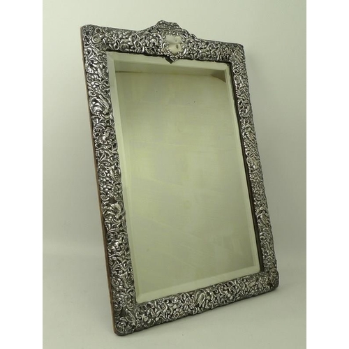 410 - A Victorian silver embossed strut mirror with rectangular bevelled plate, the frame cast with scroll... 