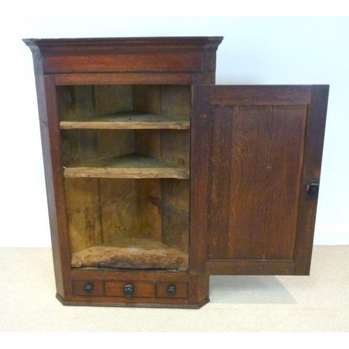 656 - A Georgian oak hanging corner cupboard, with mahogany crossbanding and shell patera to the door, enc... 