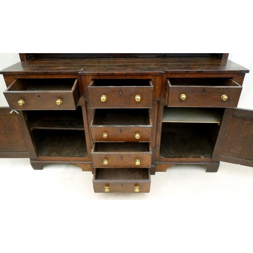 665 - An 18th century oak breakfront dresser, plate rack with three shelves and turned pilaster decoration... 