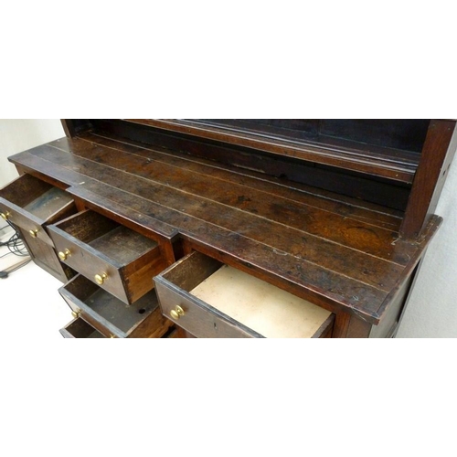 665 - An 18th century oak breakfront dresser, plate rack with three shelves and turned pilaster decoration... 