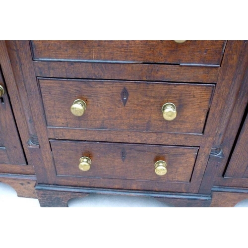 665 - An 18th century oak breakfront dresser, plate rack with three shelves and turned pilaster decoration... 