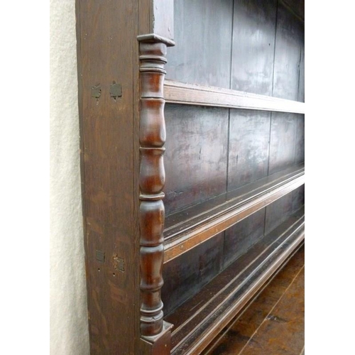 665 - An 18th century oak breakfront dresser, plate rack with three shelves and turned pilaster decoration... 