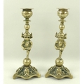 A pair of brass candlesticks modelled as Lincoln Imps, late 19th/early 20th century, each standing w... 
