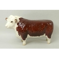 A Beswick figurine of a Hereford Bull, marked to underside 'Ch. of Champions', 19 by 11cm.