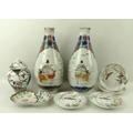 A mirrored pair of 19th century Japanese ceramic bottle vases, each decorated with a reserve depicti... 