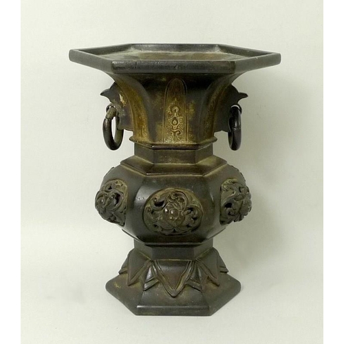 694 - A Chinese bronze vase of hexagonal baluster form, 19th century, with ring handles and raised knot de... 