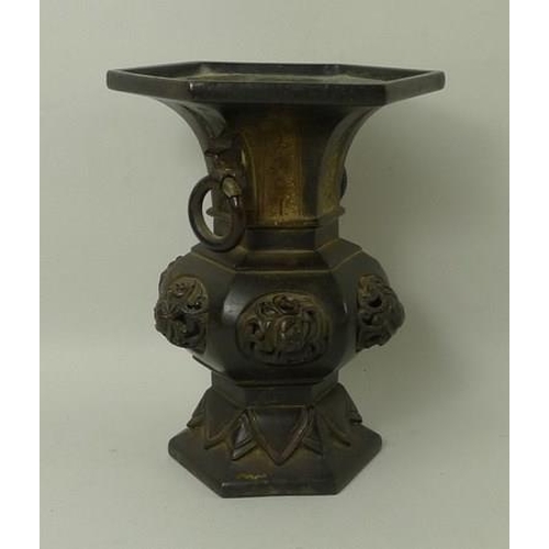 694 - A Chinese bronze vase of hexagonal baluster form, 19th century, with ring handles and raised knot de... 