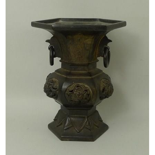 694 - A Chinese bronze vase of hexagonal baluster form, 19th century, with ring handles and raised knot de... 