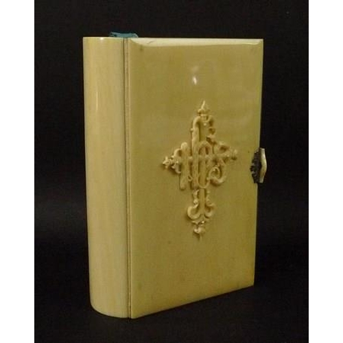 697 - An ivory bound book, 'The Book of Common Prayer', 19th century, with raised motif to front cover, si... 