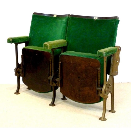 698 - A pair of folding cinema theatre seats, early 20th century, with cast iron stands and green velour u... 