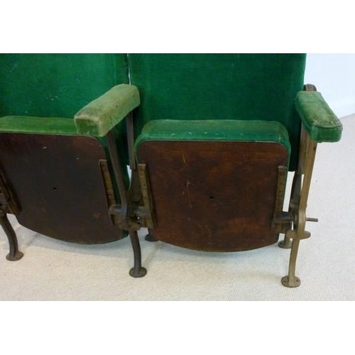 698 - A pair of folding cinema theatre seats, early 20th century, with cast iron stands and green velour u... 