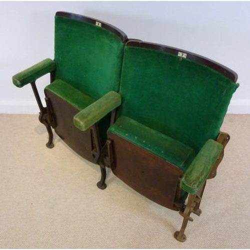 698 - A pair of folding cinema theatre seats, early 20th century, with cast iron stands and green velour u... 