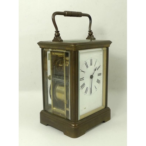 700 - A brass cased repeating carriage clock, the white enamel dial with Roman numerals, bevelled glass, a... 