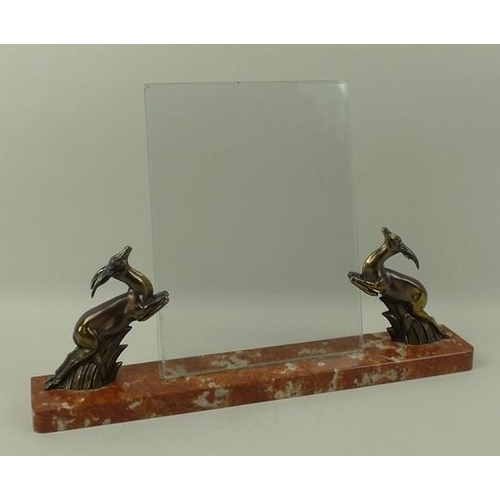 713 - An Art Deco freestanding photograph frame, the red marble plinth with two bronzed leaping springbok ... 