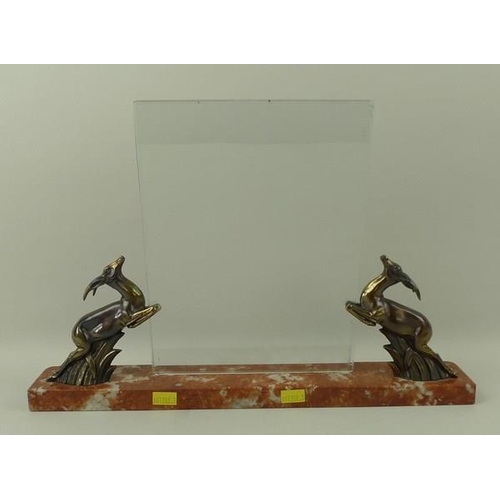 713 - An Art Deco freestanding photograph frame, the red marble plinth with two bronzed leaping springbok ... 