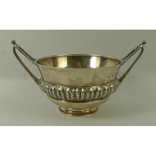 720 - An Art and Crafts silver bowl, with repeating gadrooned ellipses and two stylised elongated handles,... 