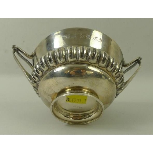 720 - An Art and Crafts silver bowl, with repeating gadrooned ellipses and two stylised elongated handles,... 