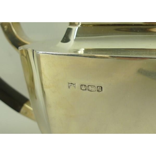 732 - An Art Deco silver three piece tea service of oblong form with incuse corners, comprising tea pot wi... 