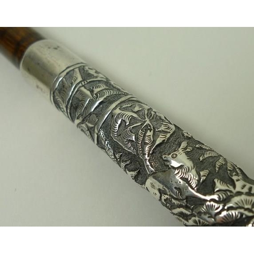 741 - An Indian silver metal parasol handle, deeply engraved with forest animals, 34cm.